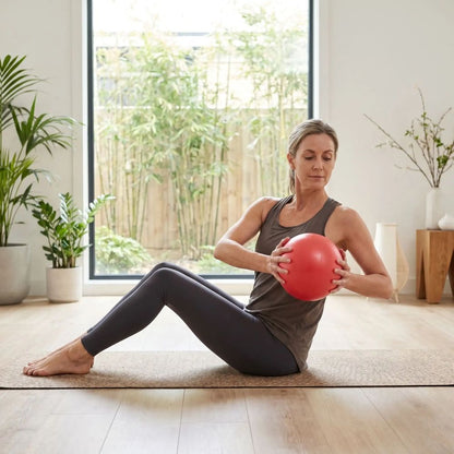 Ballon Pilates Siva 25 cm femme assis sur tapis avec ballon entre les mains