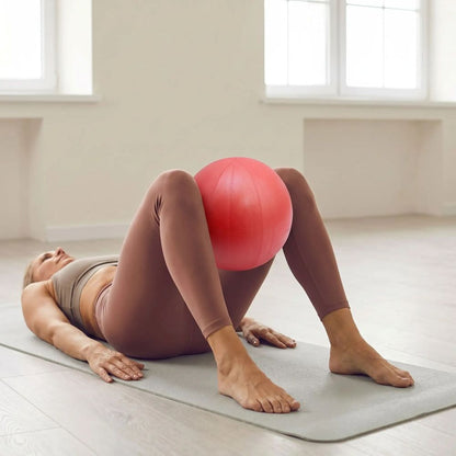 Ballon Pilates Siva 25 cm femme sur dos avec ballon entre genoux
