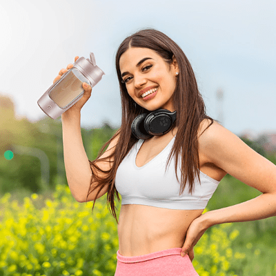 Shaker LumiPro 630 ml – Léger et facile à transporter - femme dans un champ de fleur avec son shaker Soiflex