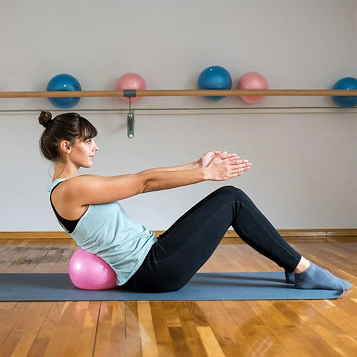 Ballon de gym Kira 25 cm – femme assis parterre avec ballon dans bas de dosCompact et pratique pour exercices - Soiflex
