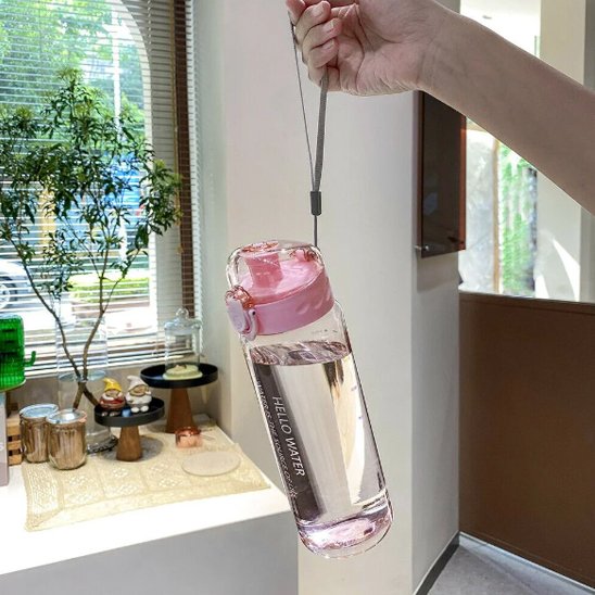Gourde sport 780 ml transparante une main tient gourde par la corde